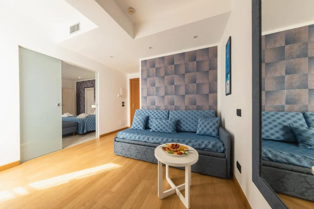 Soggiorno luminoso con divano blu e parete decorativa