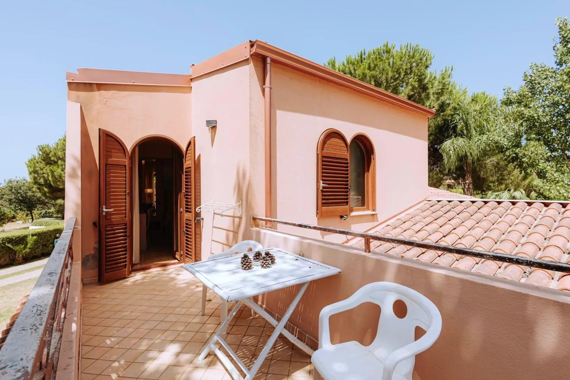 Terrazza esterna della camera con tavolino, sedie e vista sul giardino