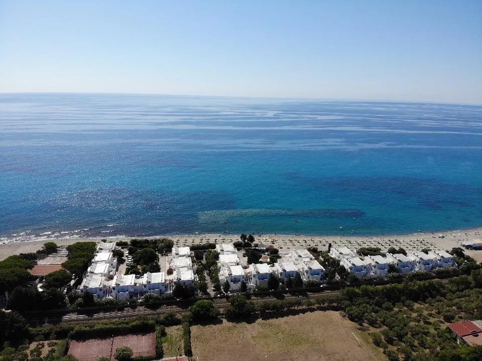 Veduta aerea del residence bianco sul mare cristallino