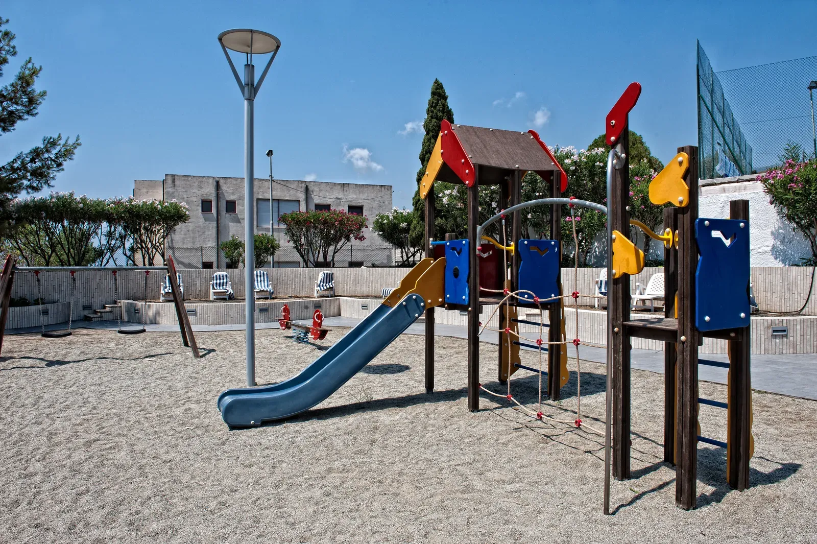 Area giochi per bambini con scivolo e altalene