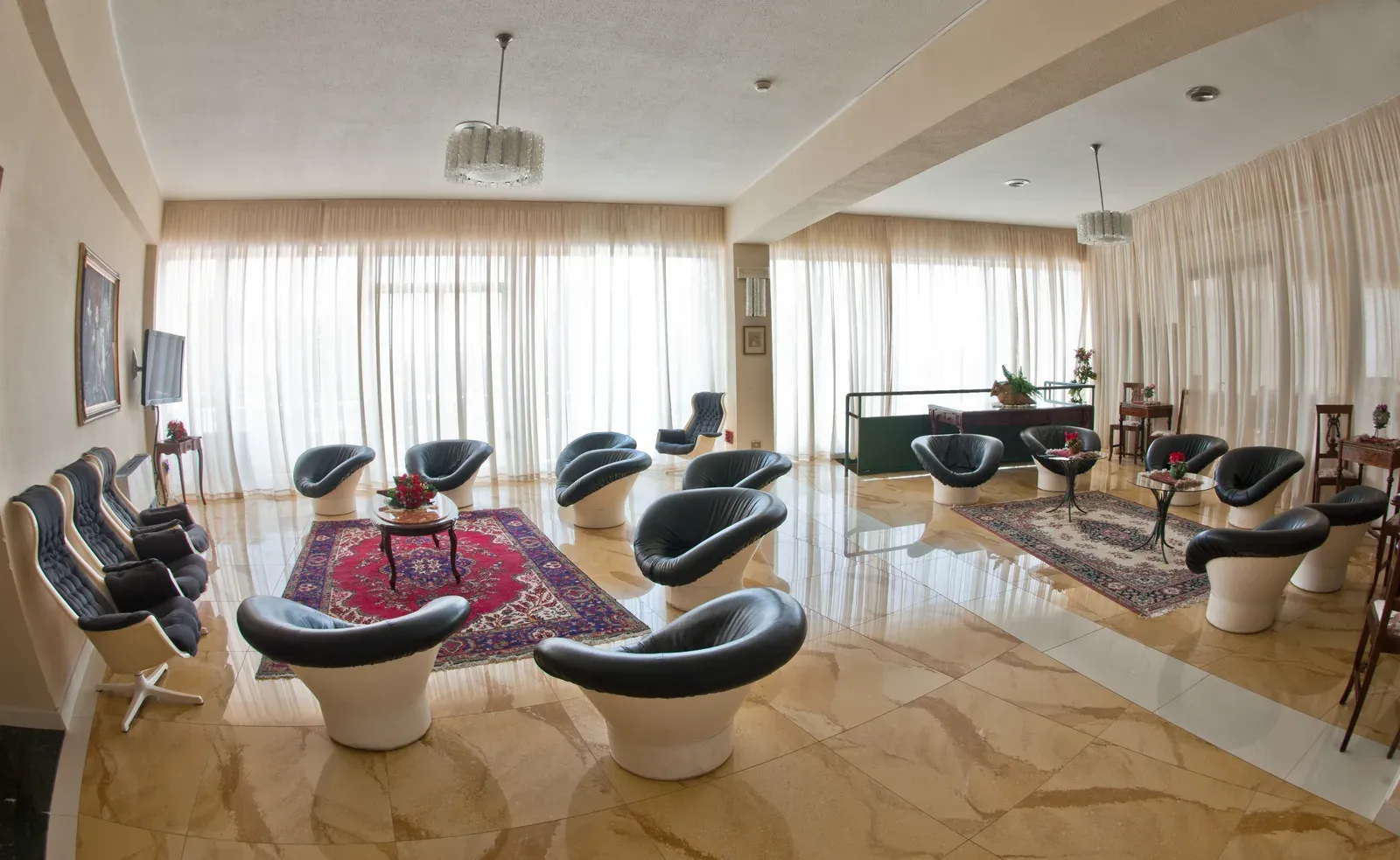 Hall dell'hotel con poltrone in pelle e ampie vetrate