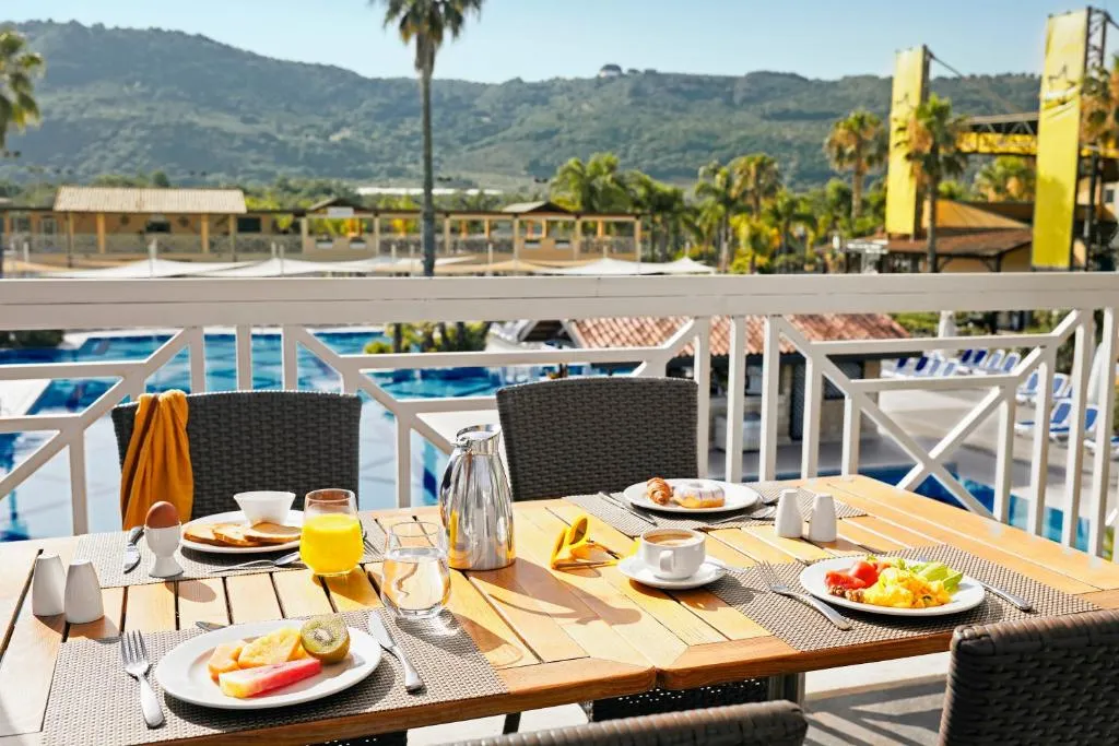 Colazione servita su tavolo in terrazza con vista sulla piscina e le colline
