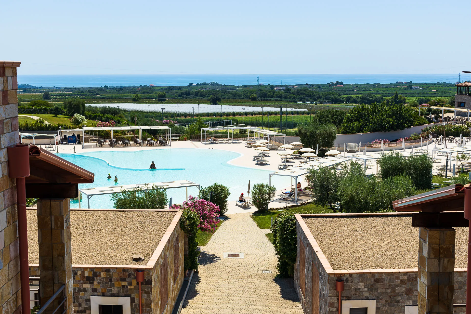 Vista panoramica sulla piscina del resort con campagna e mare sullo sfondo