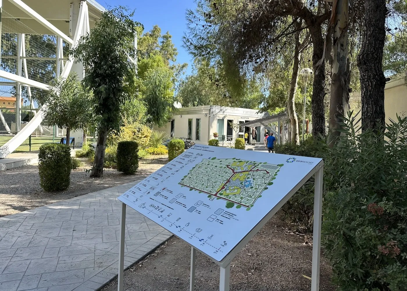 Ingresso della reception con mappa del resort e vegetazione