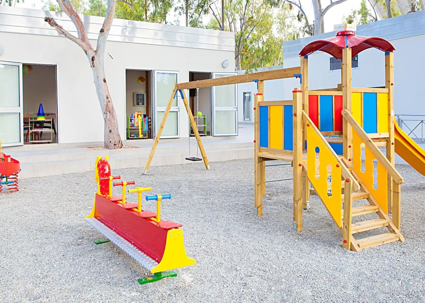 Area giochi per bambini con scivolo e altalena su ghiaia