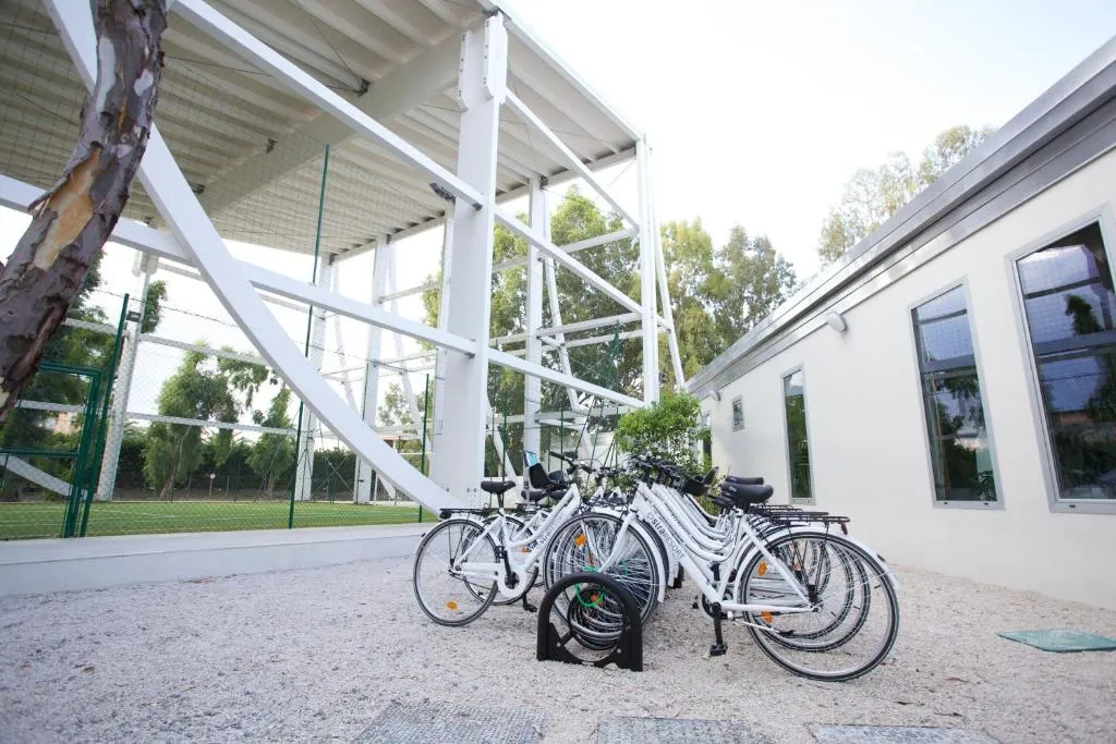 Rastrelliera con biciclette bianche a noleggio accanto al campo sportivo