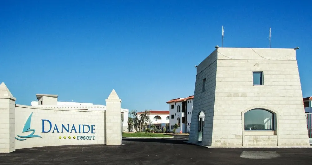 Ingresso del Danaide Resort con insegna e torre in pietra