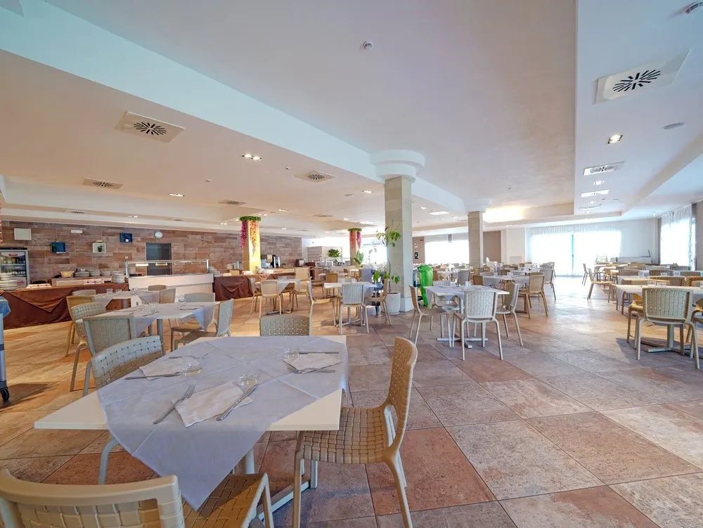 Ampia sala ristorante con tavoli apparecchiati e ambiente luminoso