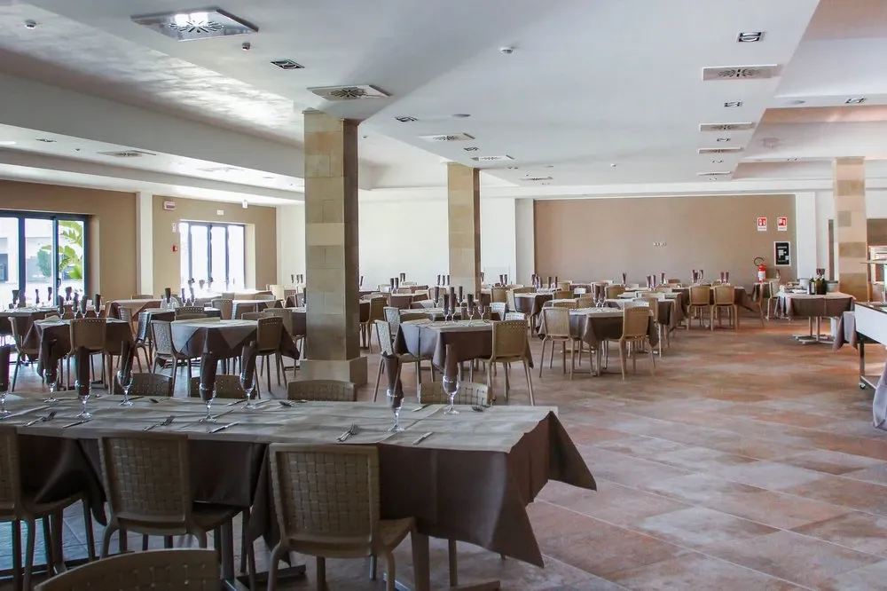 Sala da pranzo del ristorante con tavoli, tovaglie marroni e colonne