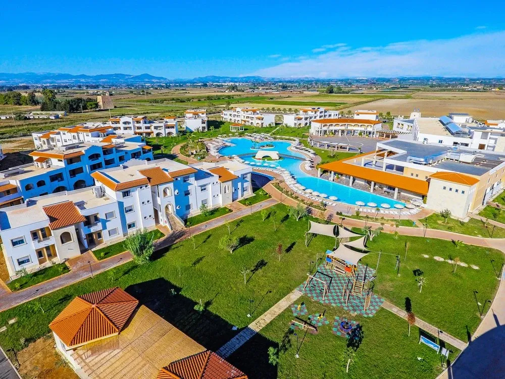 Veduta aerea del resort con piscine, edifici colorati e area giochi