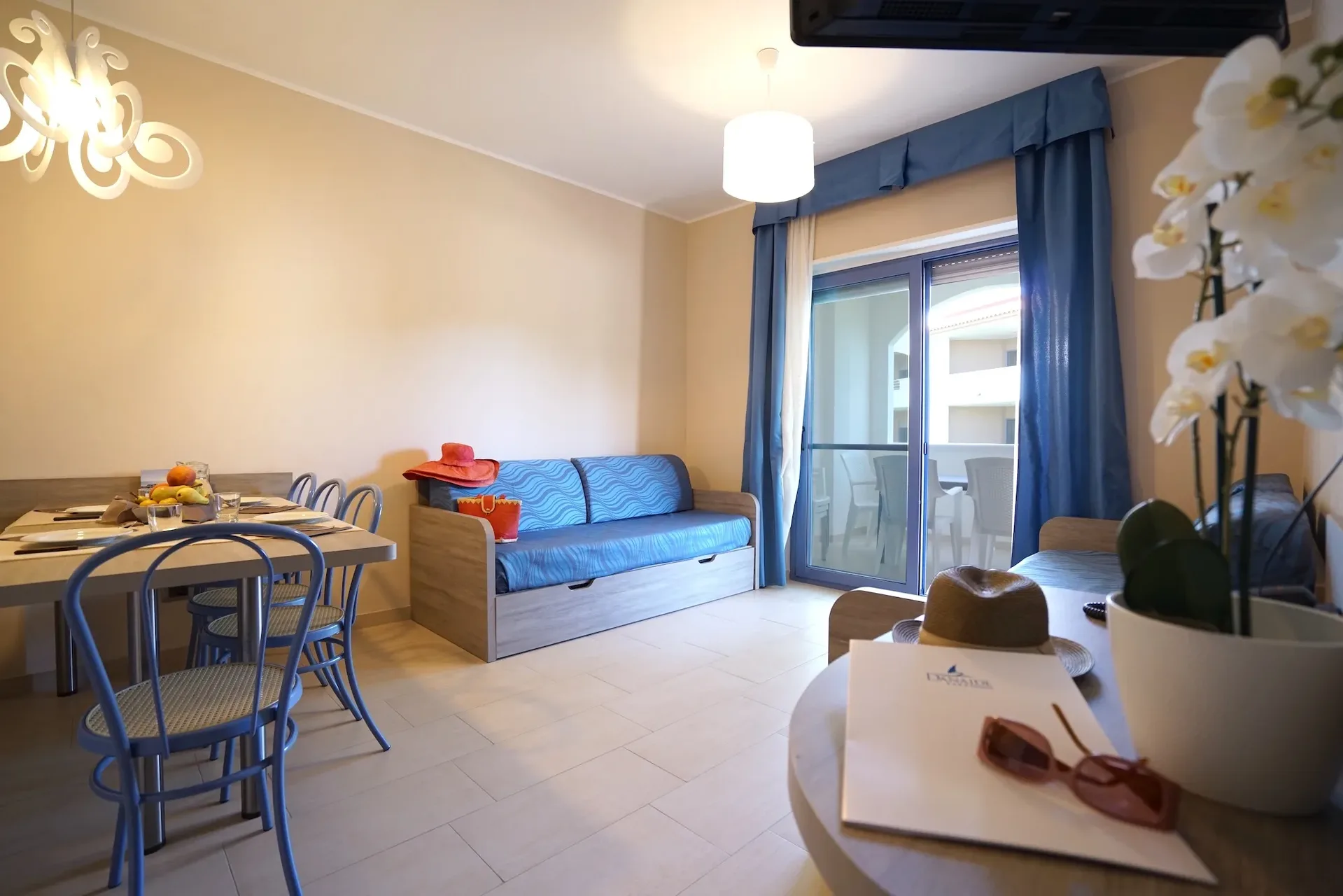Soggiorno dell'appartamento con divano, tavolo da pranzo e accesso al balcone