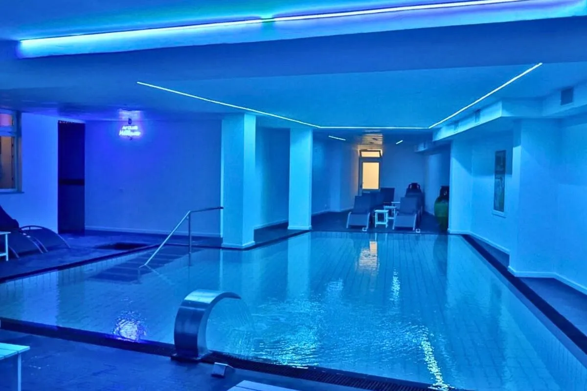 Piscina termale coperta con illuminazione blu e area relax