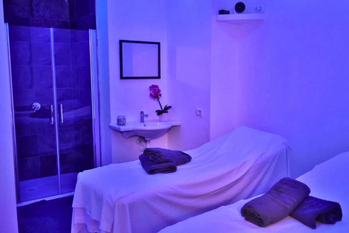 Sala massaggi con lettino e illuminazione viola rilassante