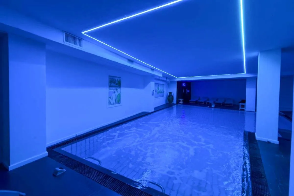 Piscina coperta illuminata di blu con soffitto a luci al neon