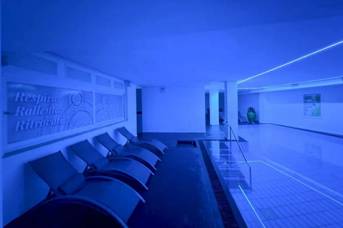 Piscina termale interna con illuminazione blu e lettini relax