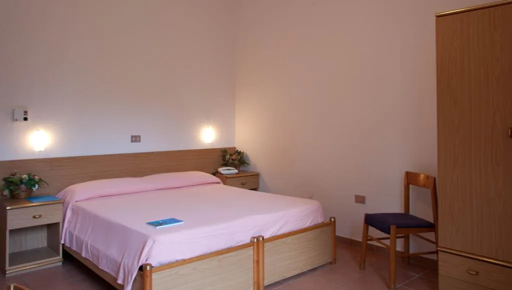 Camera con letto matrimoniale rosa, armadio in legno e sedia