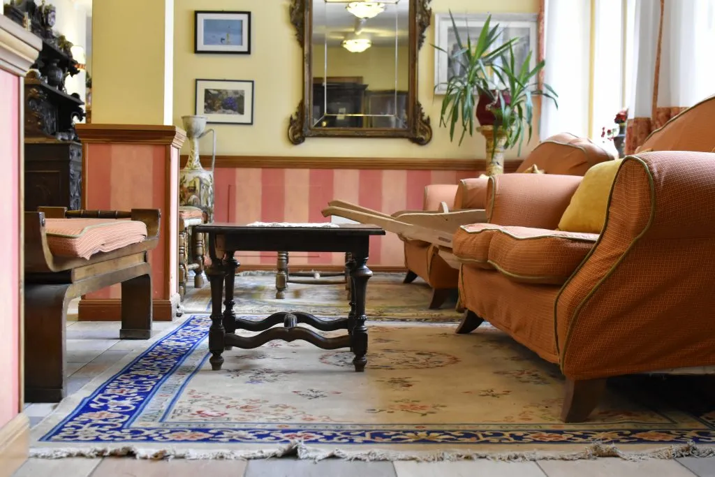 Salotto elegante con divani, tavolino in legno, tappeto orientale e specchio dorato
