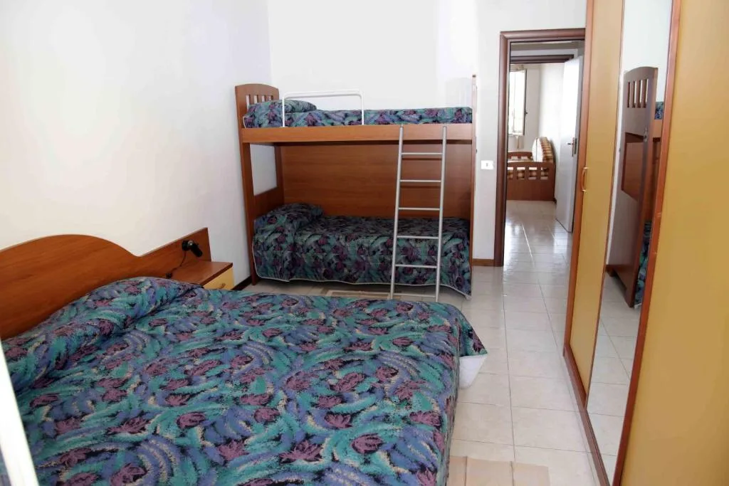 Camera con letto matrimoniale e letto a castello, arredi in legno