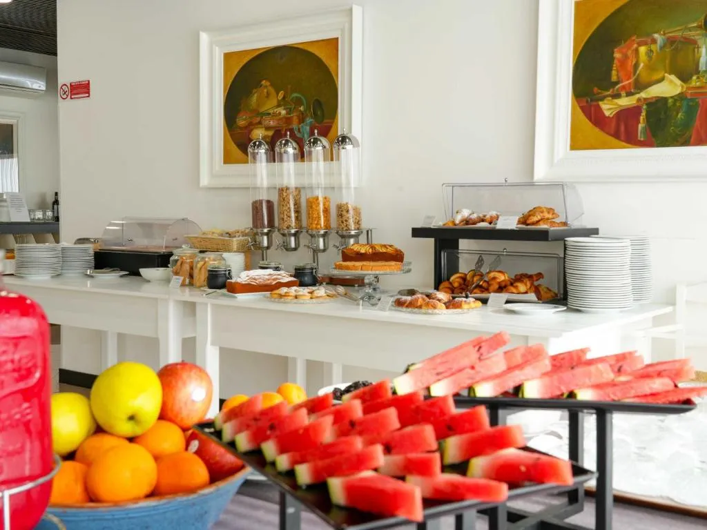 Buffet della colazione con dolci, croissant, cereali e frutta fresca come anguria e agrumi