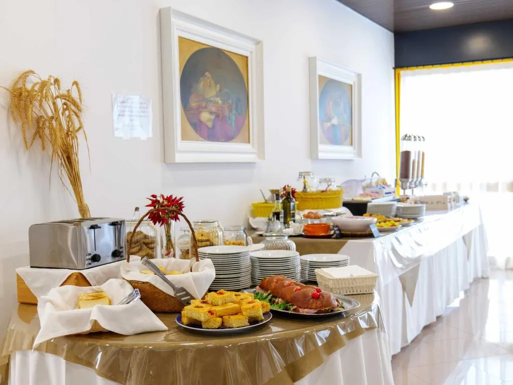 Buffet con salumi, formaggi, pane, tostapane e piatti caldi allestito su tavoli con tovaglie