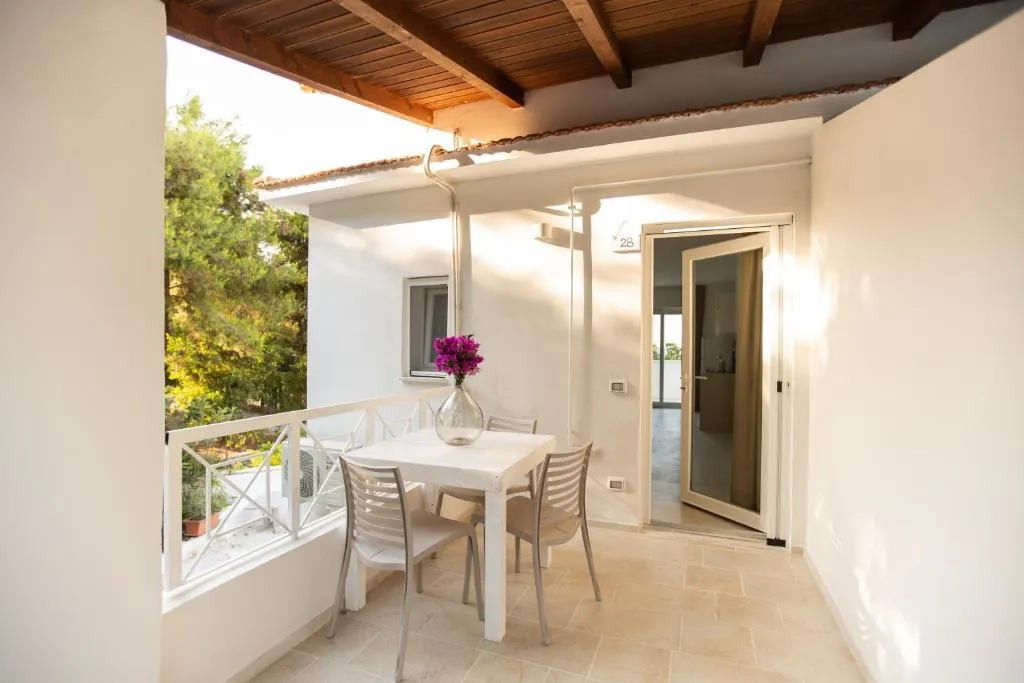 Balcone con tavolo e sedie bianche e travi in legno a vista