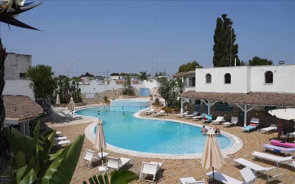 Veduta dall'alto della piscina con lettini e ospiti in giornata di sole
