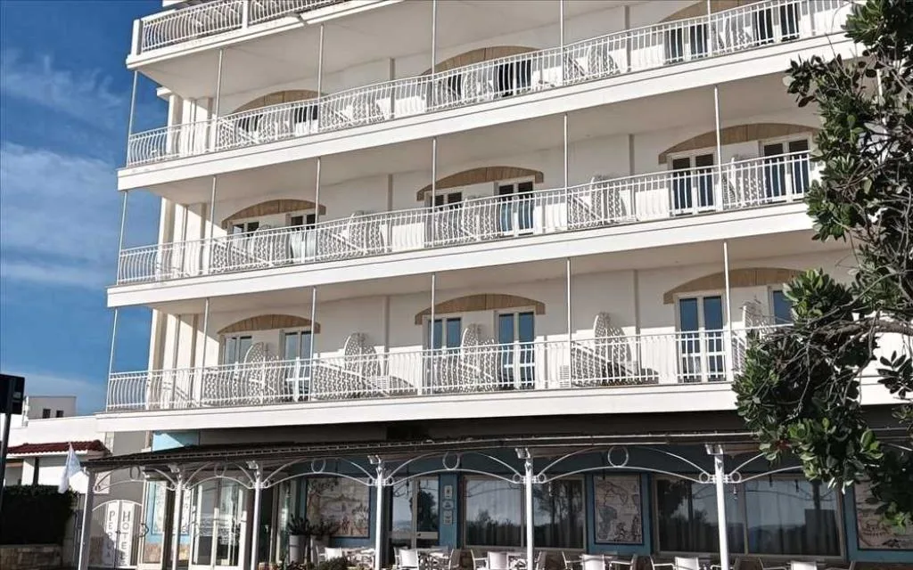 Facciata dell'hotel con balconi e cielo azzurro limpido