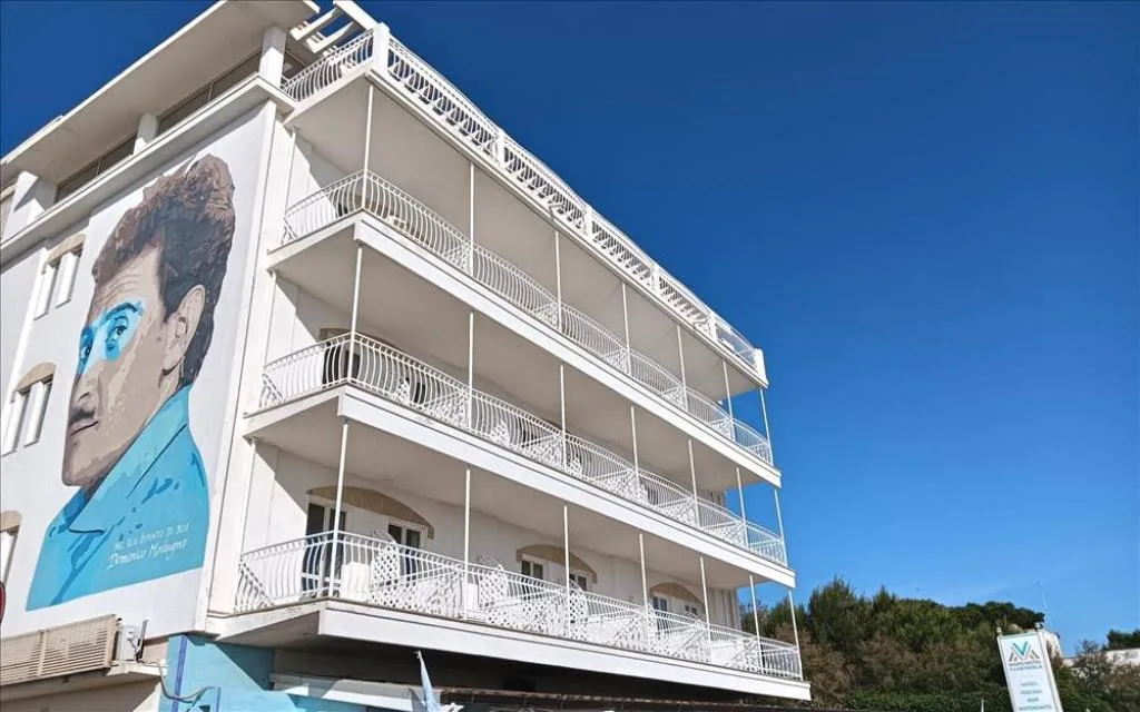 Facciata dell'hotel con murale artistico e balconi sotto cielo sereno