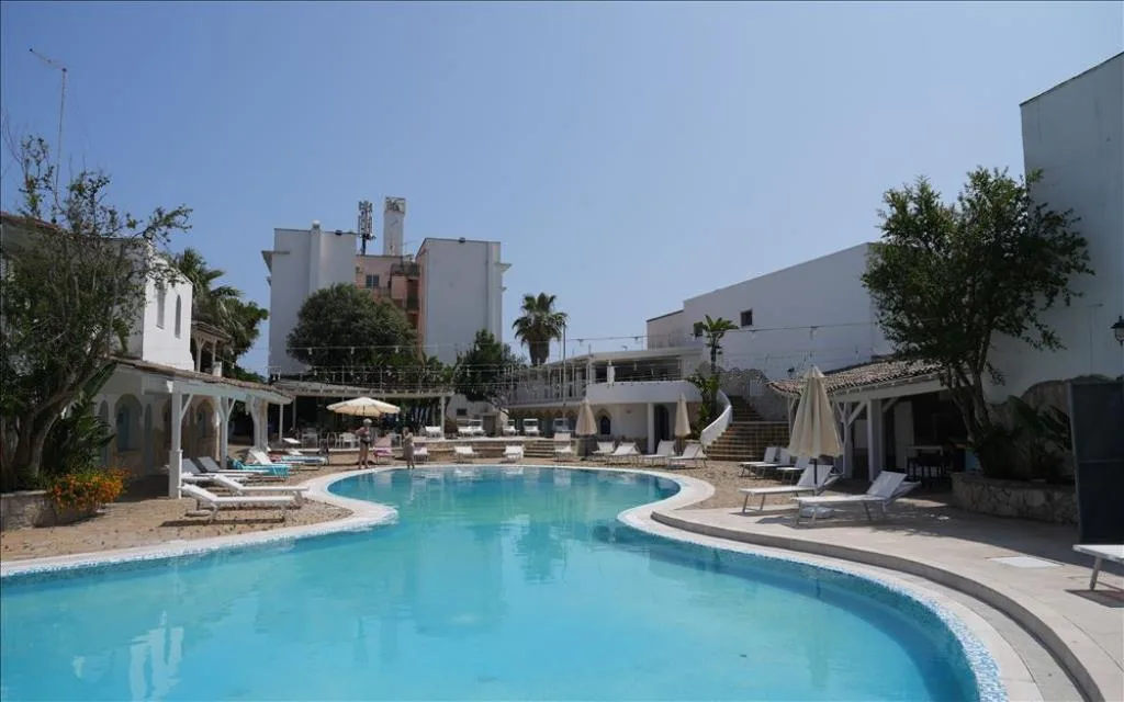 Ampia piscina all'aperto con lettini e ombrelloni in giornata soleggiata