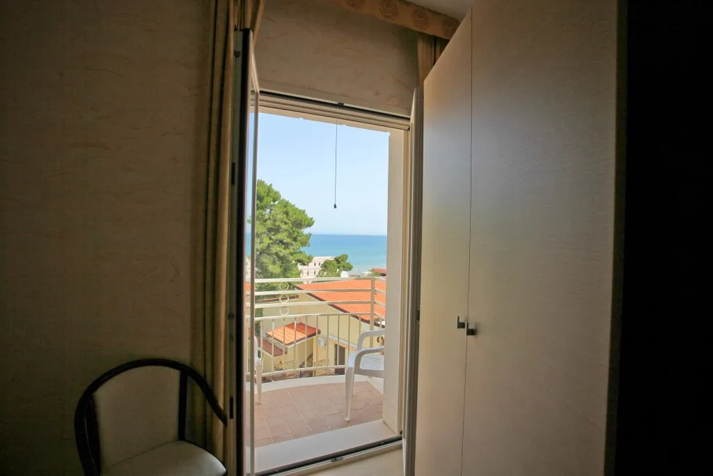 Vista sul mare dal balcone della camera attraverso la porta finestra