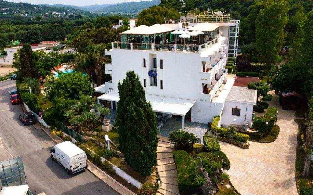 Veduta aerea dell'hotel bianco con terrazza panoramica immerso nel verde