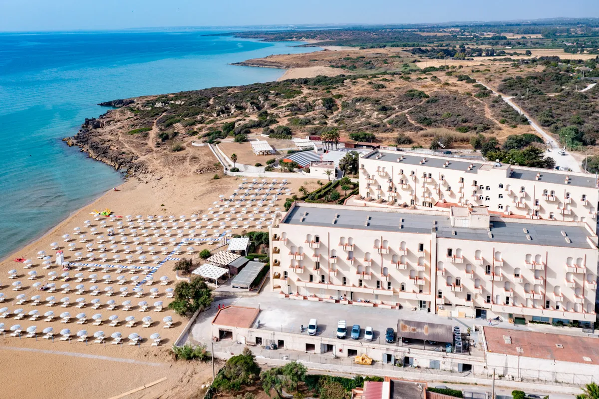 Vista aerea dell'hotel con spiaggia attrezzata e mare turchese