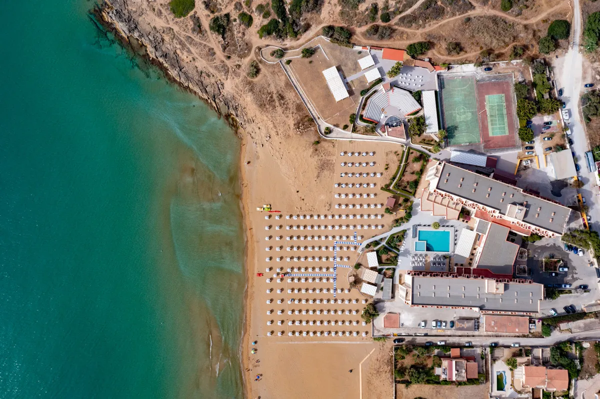 Vista aerea zenitale dell'hotel, piscina e spiaggia sul mare