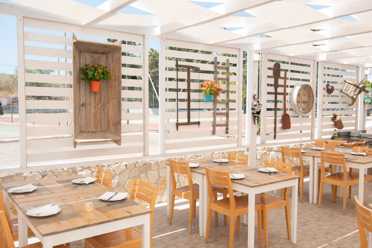Ristorante all'aperto con tavoli in legno e decorazioni rustiche