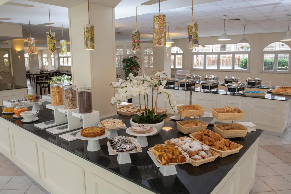 Buffet della colazione con dolci, cornetti e frutta fresca