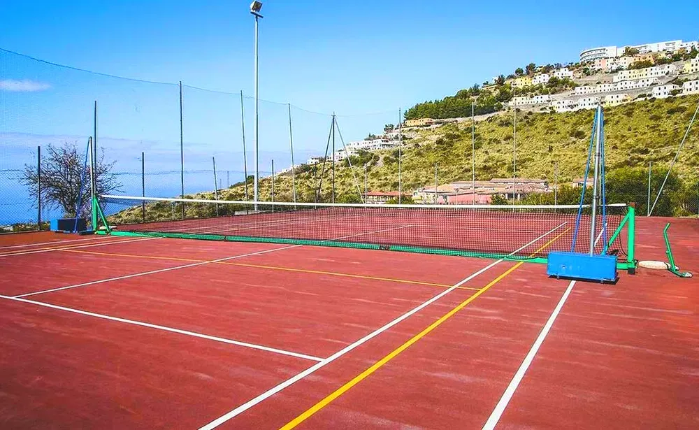 Campo da tennis in terra rossa con vista panoramica sulla collina