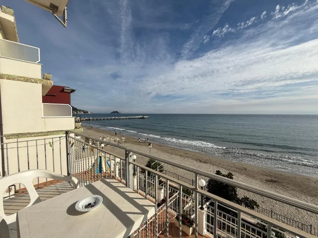 Balcone con tavolino e vista panoramica sulla spiaggia, il mare e il pontile