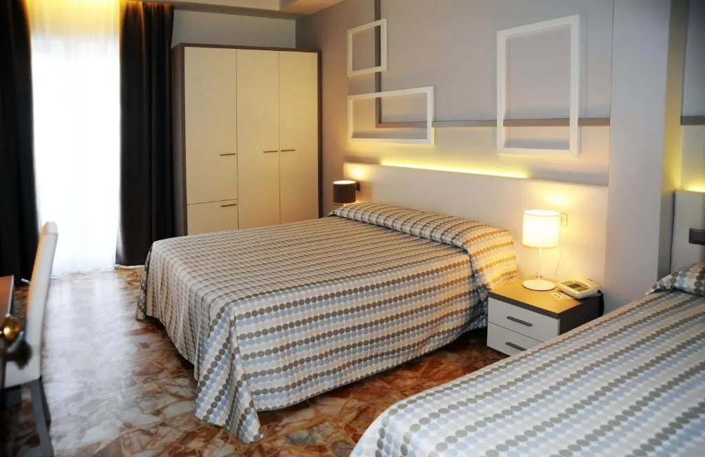 Camera tripla con letto matrimoniale e singolo, armadio e illuminazione moderna