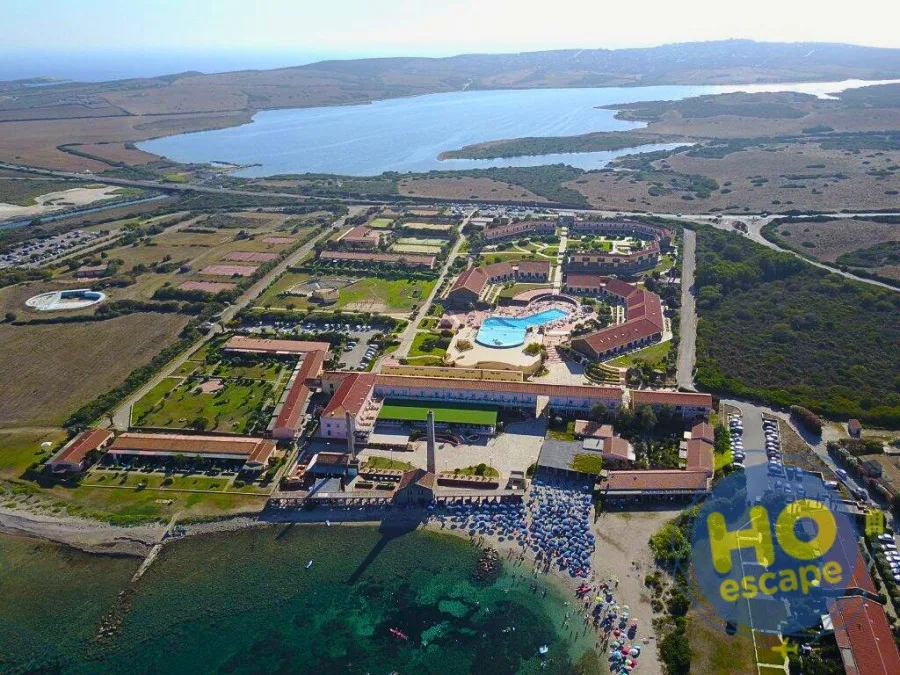 Panoramica aerea del resort con piscina, edifici e laguna sul retro