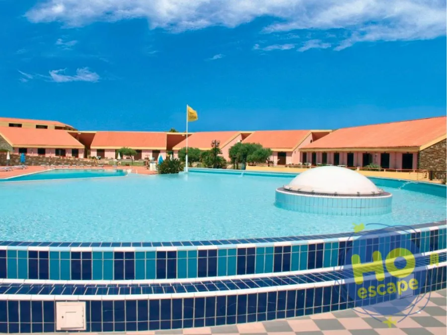 Ampia piscina rotonda con fontana a cupola e edifici dai tetti rossi