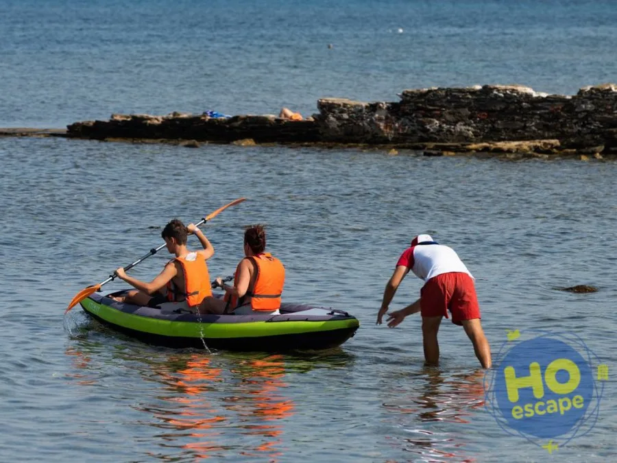 Ospiti in canoa con giubbotti di salvataggio assistiti da un bagnino nel mare calmo