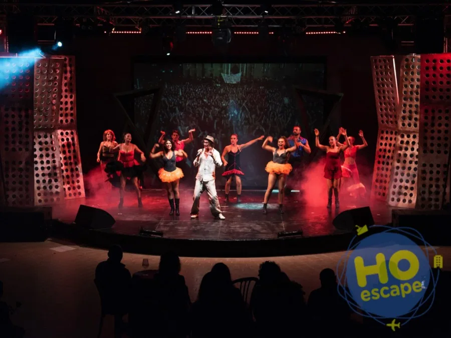 Spettacolo serale con ballerini e cantante sul palco illuminato del teatro dell'hotel
