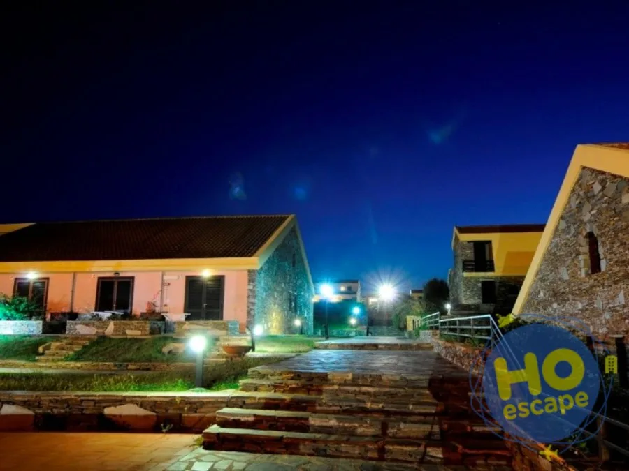 Edifici in pietra dell'hotel illuminati di notte con scalinate e giardino