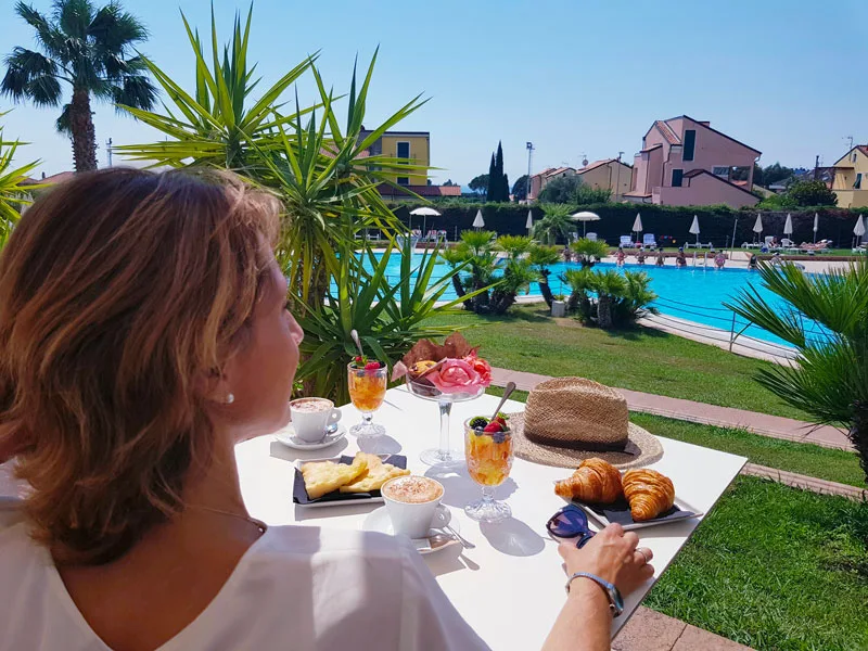 Colazione all'aperto con cappuccino e cornetti vista piscina