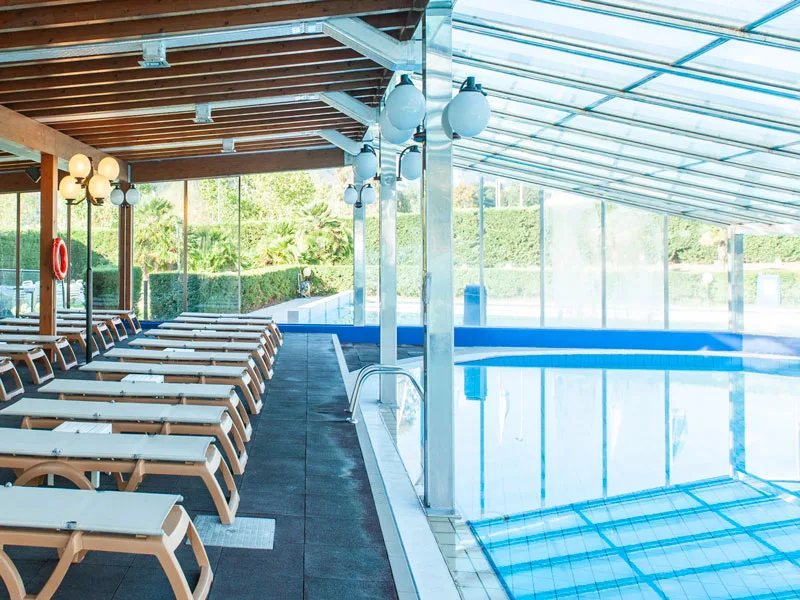 Piscina coperta con lettini e copertura in vetro