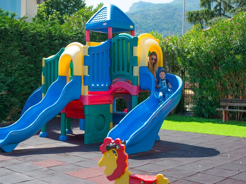 Area giochi per bambini con scivoli colorati nel giardino dell'hotel