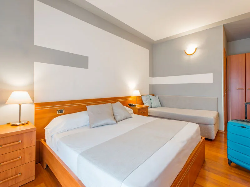Camera da letto con letto matrimoniale, divano e arredi in legno