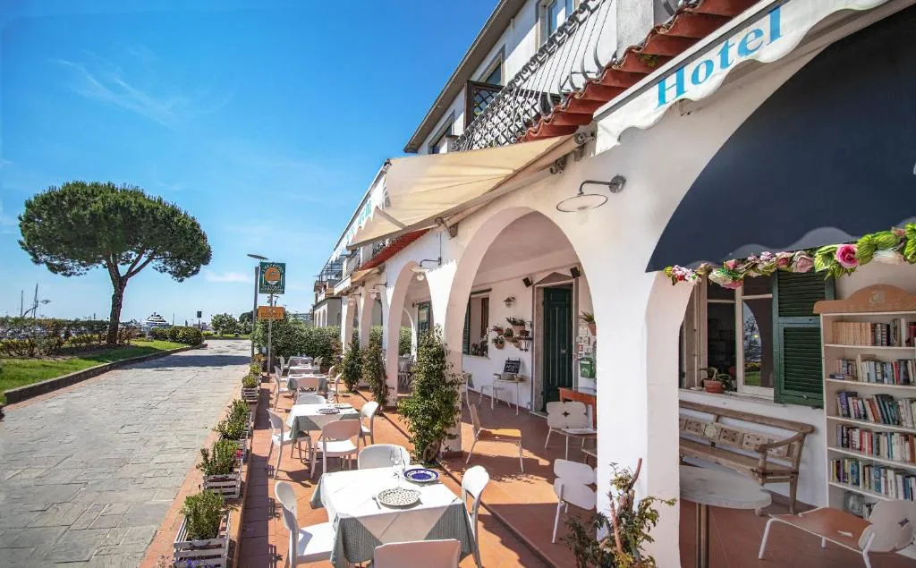 Terrazza esterna dell'hotel con tavoli apparecchiati sotto il portico ad archi