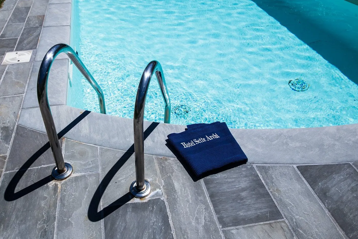 Dettaglio della scaletta della piscina con telo blu Hotel Sette Archi