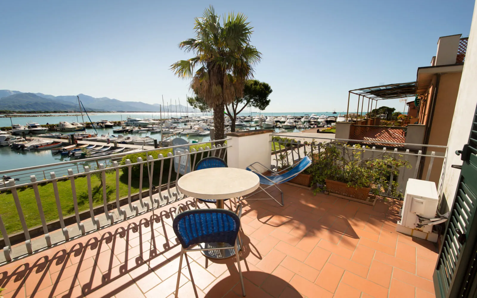 Terrazza privata con tavolino e sdraio affacciata sul porto turistico e il mare
